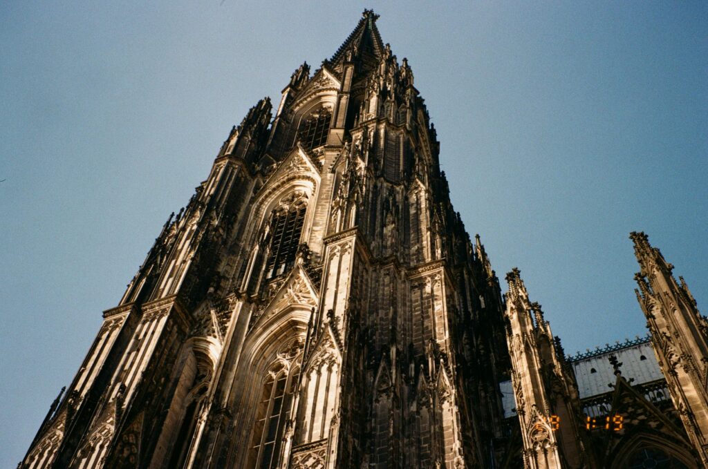 Vista em contrapicado da torre gótica da Catedral de Colônia contra o céu azul